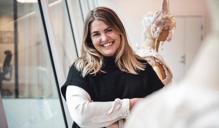 Jennie Pettersson står lutad mot ett fönster med armarna i kors på BillerudKorsnäs kontor.