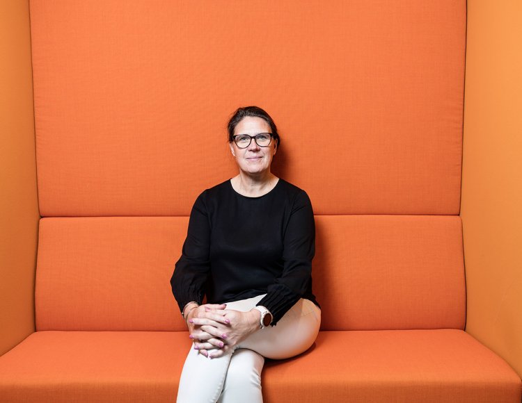 Karin Olholt sitter i orange soffa på Kraftringens kontor.
