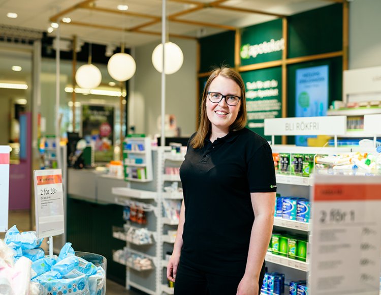 Apotekets nationella resurs Julia Kappinen ståendes i en av Apotekets butiker. 